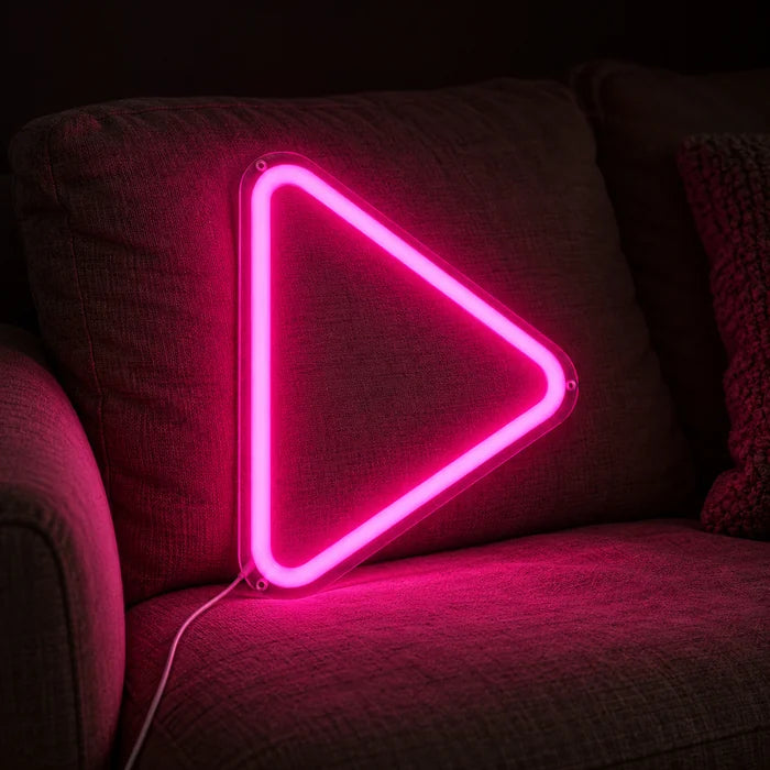 Play Neon LED Schild auf einem gemütlichen Sofa zwischen Kissen und Decke