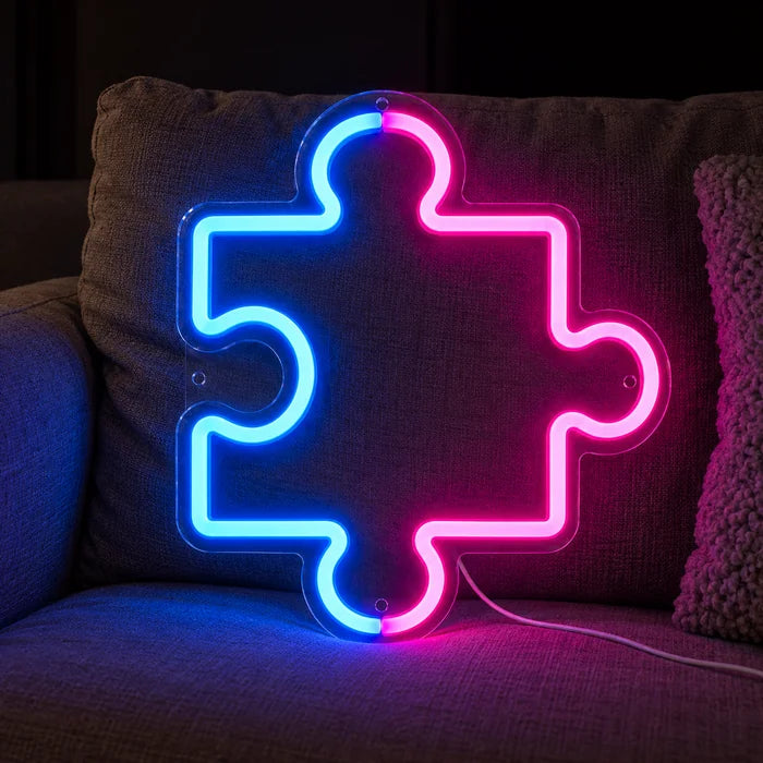 Puzzleteil Neon LED Schild auf einem gemütlichen Sofa zwischen Kissen und Decke