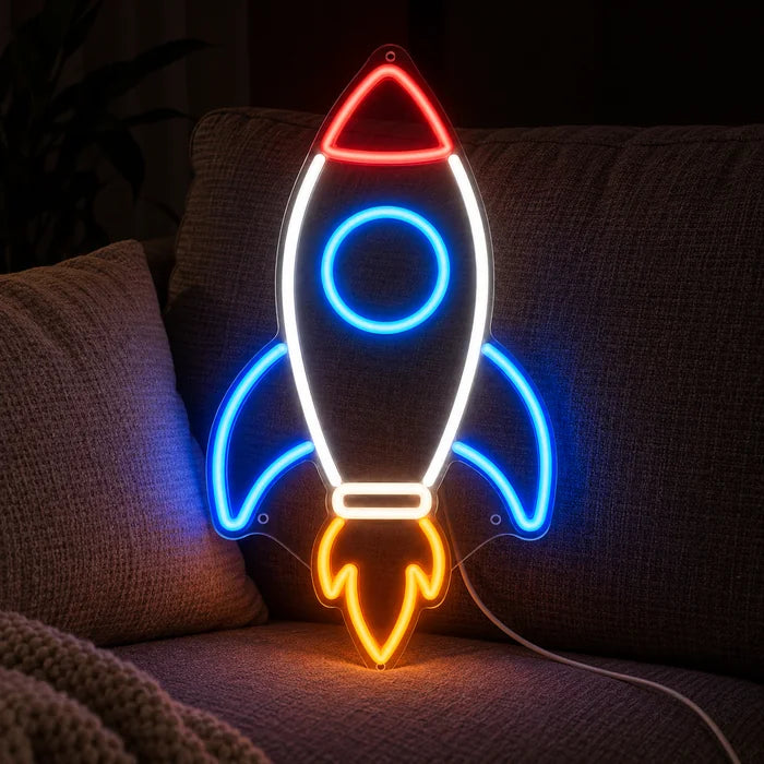 Retro-Rakete Neon LED Schild auf einem gemütlichen Sofa zwischen Kissen und Decke