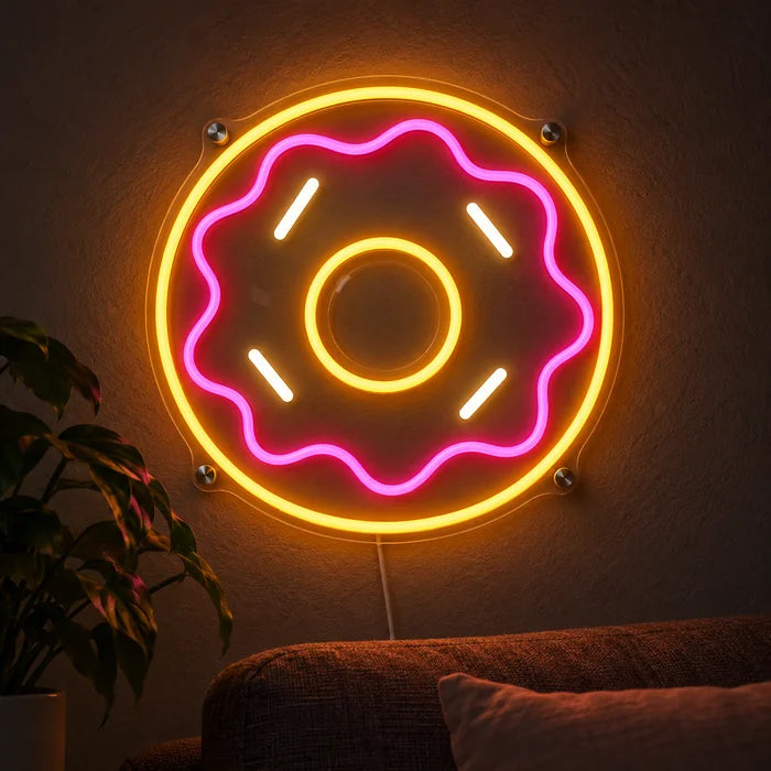 Rosa Donut Neon LED Schild leuchtend an einer dunklen Wand, Nahaufnahme mit Anschlusskabel
