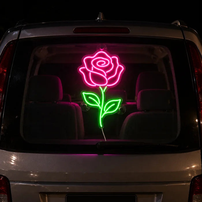 Rosenlicht Neon LED Schild an der Heckscheibe eines Autos bei Nacht