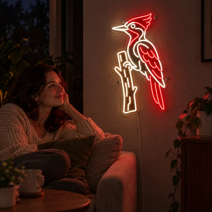 Roter Specht Neon LED Schild an der Wohnzimmerwand, davor entspannt eine Person auf dem Sofa