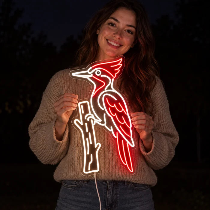 Roter Specht Neon LED Schild in den Händen einer lächelnden Frau vor dunklem Hintergrund