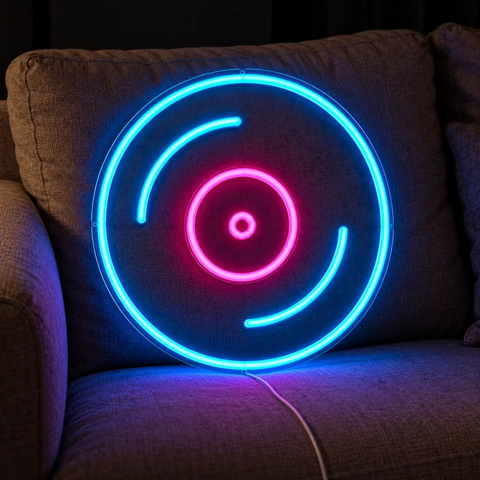 Schallplatte Neon LED Schild auf einem gemütlichen Sofa zwischen Kissen und Decke