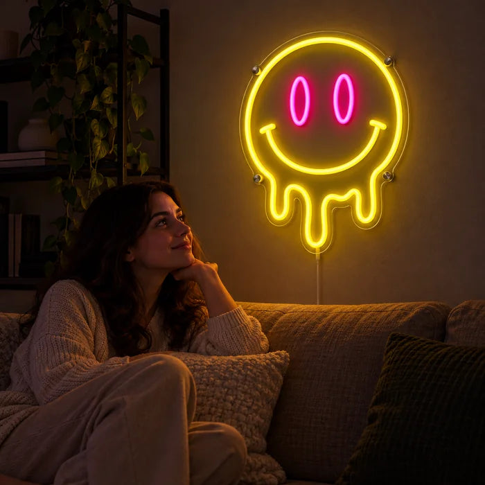 Schmelzender Smiley Neon LED Schild an der Wohnzimmerwand, davor entspannt eine Person auf dem Sofa