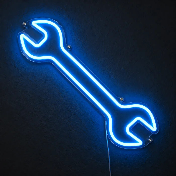 Schraubenschlüssel Neon LED Schild leuchtend an einer dunklen Wand, Nahaufnahme mit Anschlusskabel