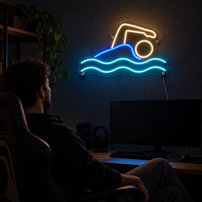 Schwimmer Neon LED Schild über dem Gaming-Schreibtisch, davor ein Spieler im Gaming-Stuhl