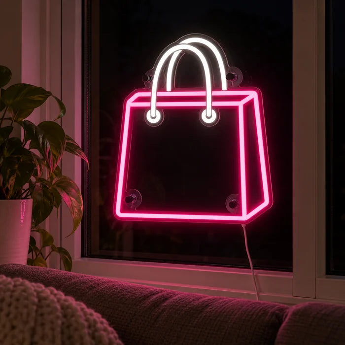 Shoppingtasche Neon LED Schild abends im Fenster eines gemütlichen Wohnzimmers
