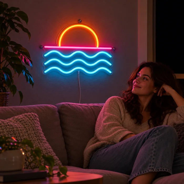 Sonnenuntergang am Meer Neon LED Schild an der Wohnzimmerwand, davor entspannt eine Person auf dem Sofa