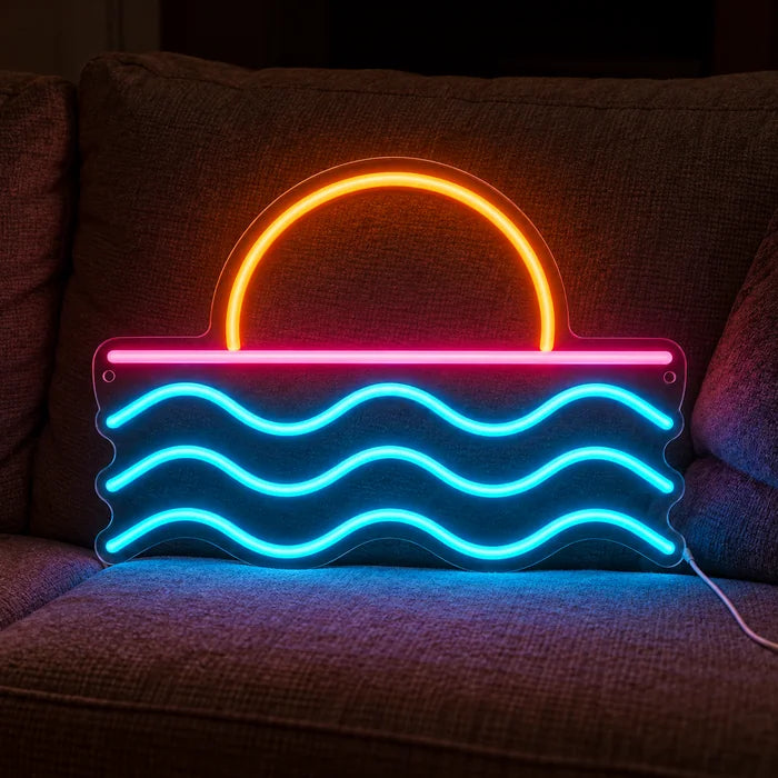 Sonnenuntergang am Meer Neon LED Schild auf einem gemütlichen Sofa zwischen Kissen und Decke