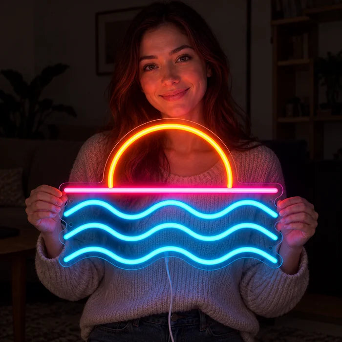 Sonnenuntergang am Meer Neon LED Schild in den Händen einer lächelnden Frau vor dunklem Hintergrund