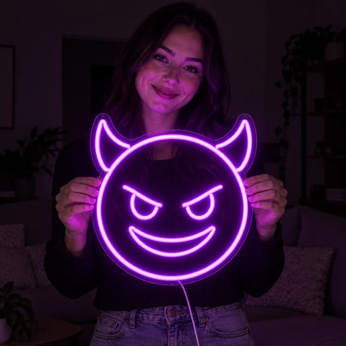 Teufelsgrinsen Neon LED Schild in den Händen einer lächelnden Frau vor dunklem Hintergrund