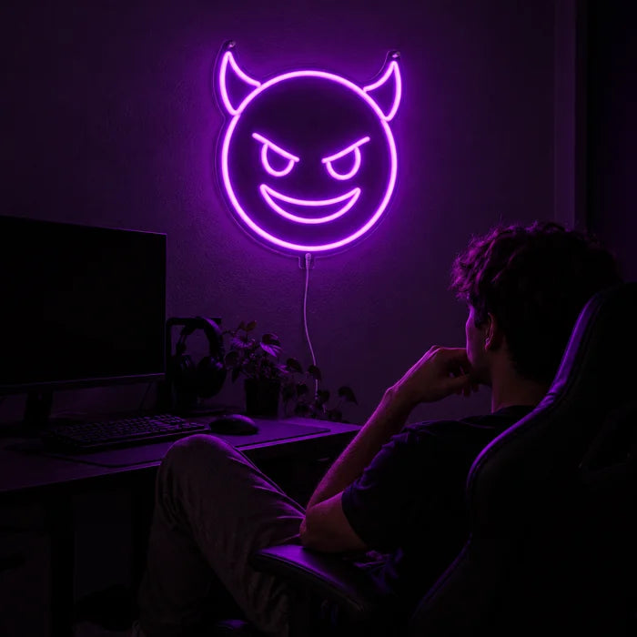 Teufelsgrinsen Neon LED Schild über dem Gaming-Schreibtisch, davor ein Spieler im Gaming-Stuhl