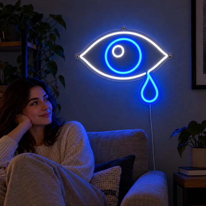 Tränenauge Neon LED Schild an der Wohnzimmerwand, davor entspannt eine Person auf dem Sofa