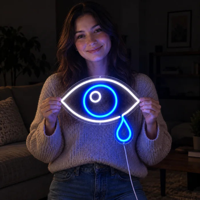 Tränenauge Neon LED Schild in den Händen einer lächelnden Frau vor dunklem Hintergrund