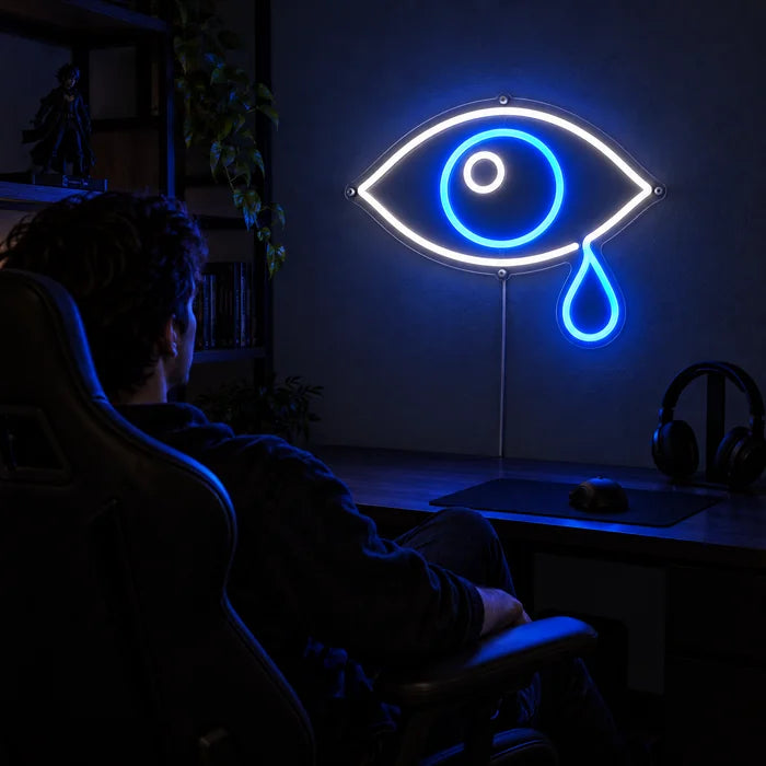 Tränenauge Neon LED Schild über dem Gaming-Schreibtisch, davor ein Spieler im Gaming-Stuhl