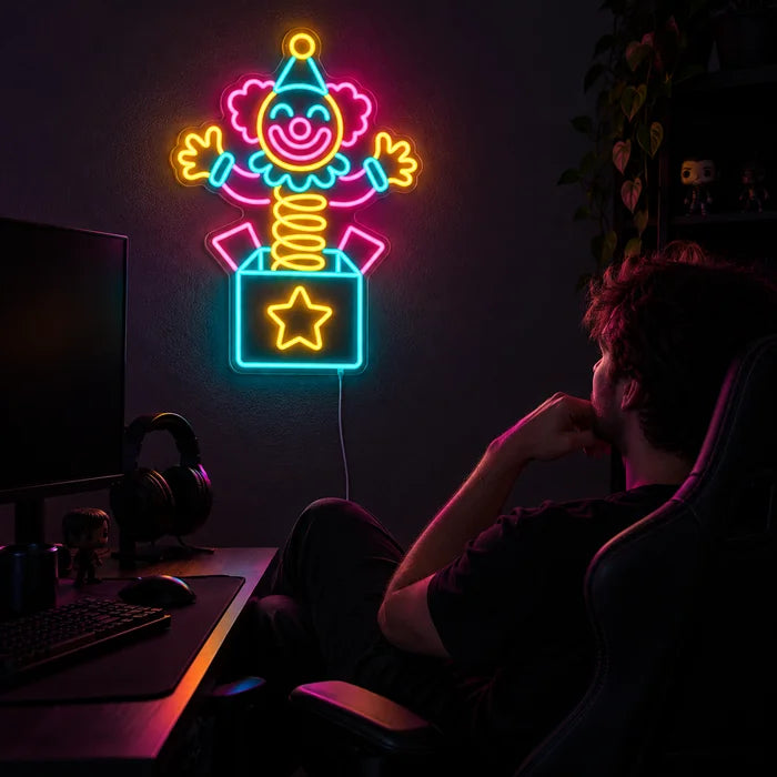 Überraschungsclown Neon LED Schild über dem Gaming-Schreibtisch, davor ein Spieler im Gaming-Stuhl