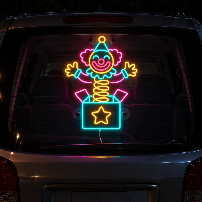 Überraschungsclown Neon LED Schild an der Heckscheibe eines Autos bei Nacht