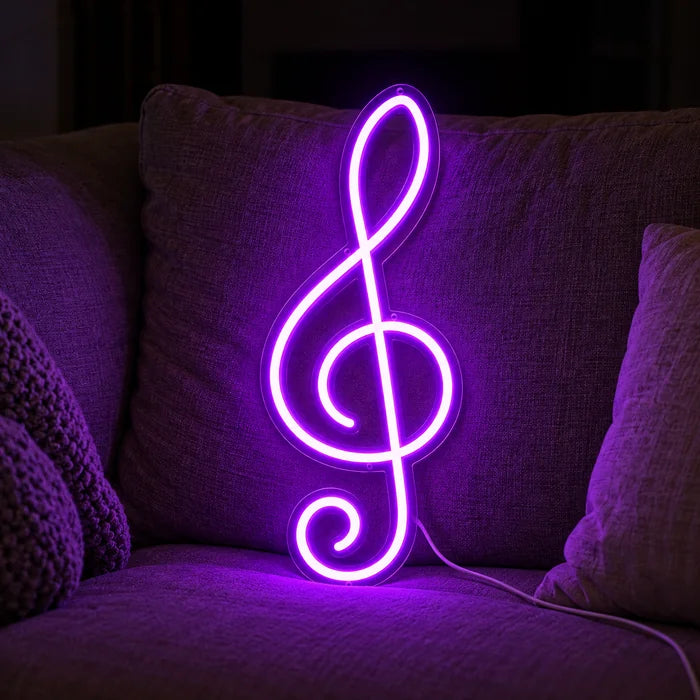 Violinschlüssel Neon LED Schild auf einem gemütlichen Sofa zwischen Kissen und Decke
