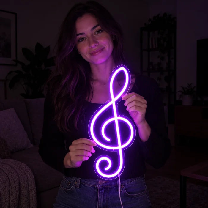 Violinschlüssel Neon LED Schild in den Händen einer lächelnden Frau vor dunklem Hintergrund