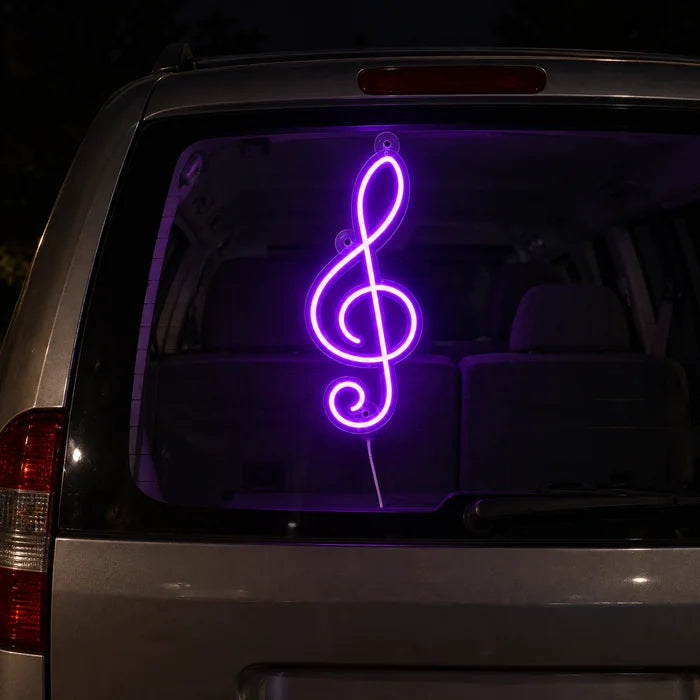 Violinschlüssel Neon LED Schild an der Heckscheibe eines Autos bei Nacht