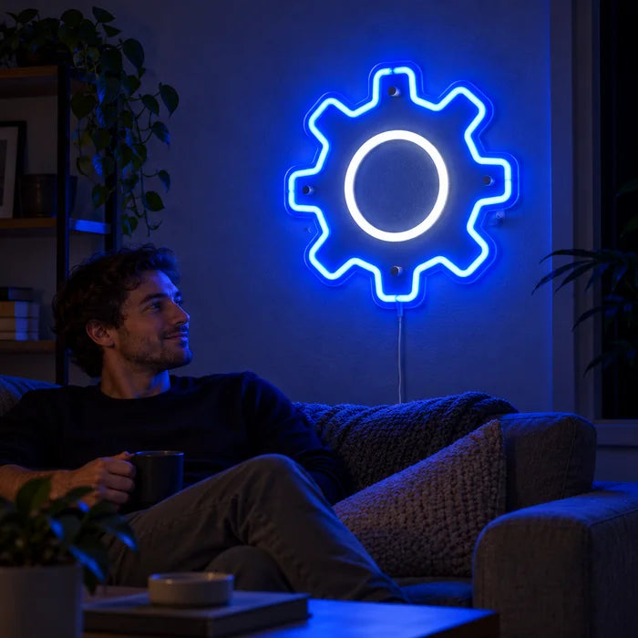 Zahnrad Neon LED Schild an der Wohnzimmerwand, davor entspannt eine Person auf dem Sofa