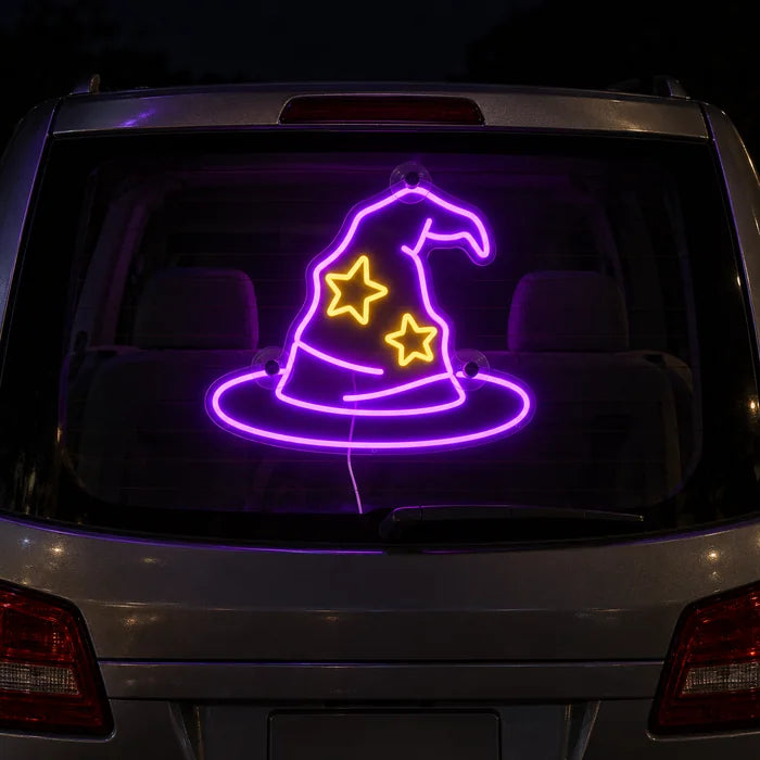 Zauberhut Neon LED Schild an der Heckscheibe eines Autos bei Nacht