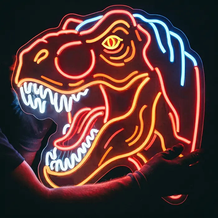 T-Rex Dino Neon LED Schild in Nahaufnahme in zwei Händen, rote Konturen und weiße Zähne leuchten