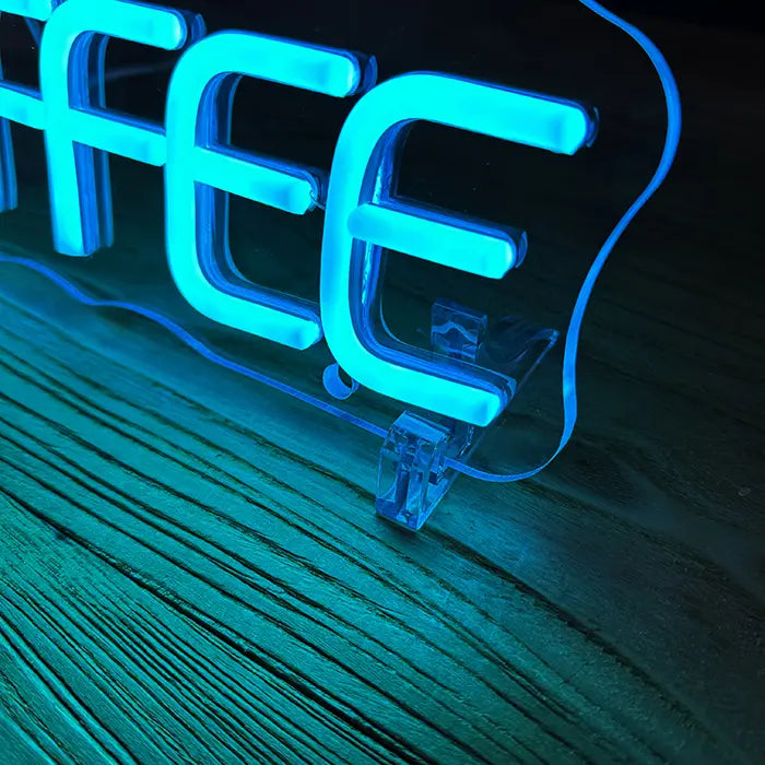 Coffee Tasse Neon LED Schild im Detail mit Standfuß auf einer Holzfläche, Buchstaben leuchten