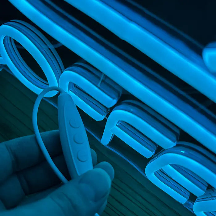 Coffee Tasse Neon LED Schild aus der Nähe mit Inline-Dimmer in der Hand vor den Buchstaben