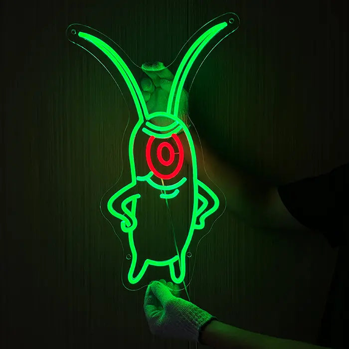 The Plankton Neon LED Schild wird mit Handschuhen an eine dunkle Wand gehalten