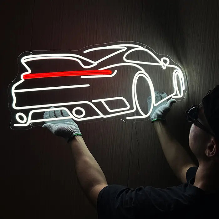 GT-Sportwagen Neon LED Schild wird an der Wand ausgerichtet, eine Person mit Handschuhen hält es fest