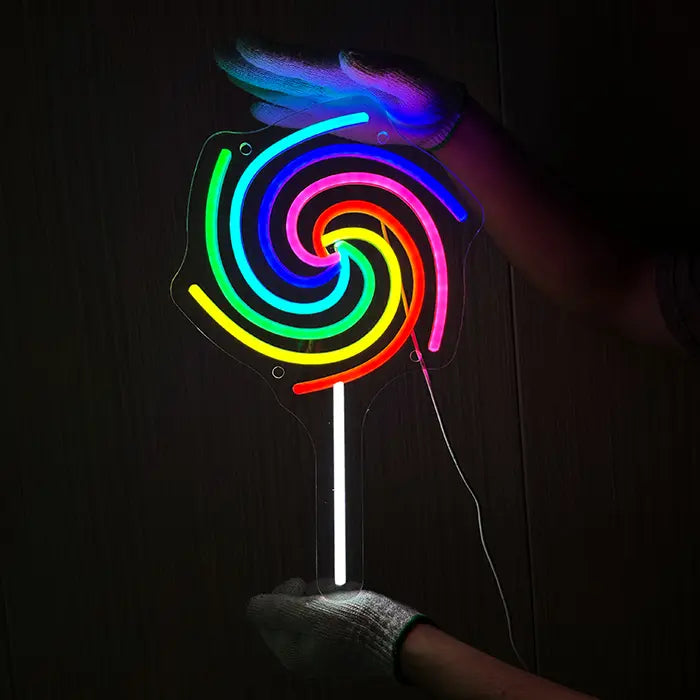 Lollipop Neon LED Schild wird mit Handschuhen an eine dunkle Holzwand gehalten und ausgerichtet