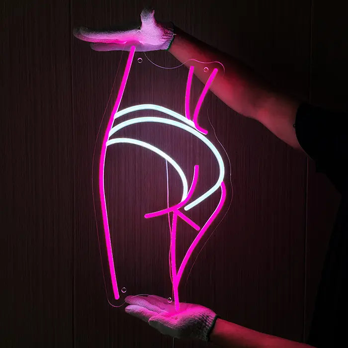 Sexy Boogie Neon LED Schild wird mit Handschuhen an eine dunkle Holzwand gehalten