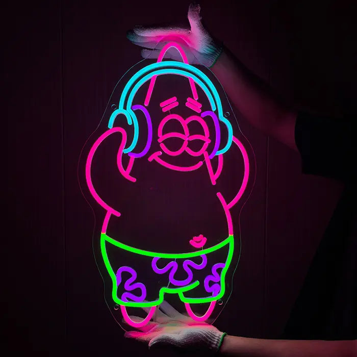 Patrick Musik Neon LED Schild von zwei Händen in Handschuhen vor einer dunklen Wand gehalten