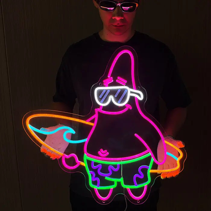 Patrick Surfer Neon LED Schild von einem Mann mit Sonnenbrille vor dem Körper gehalten