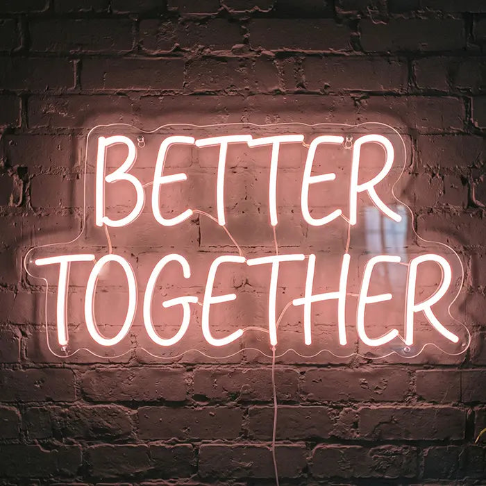 Better Together Neon LED Schild in Warmweiß mit Großbuchstaben an einer Backsteinwand