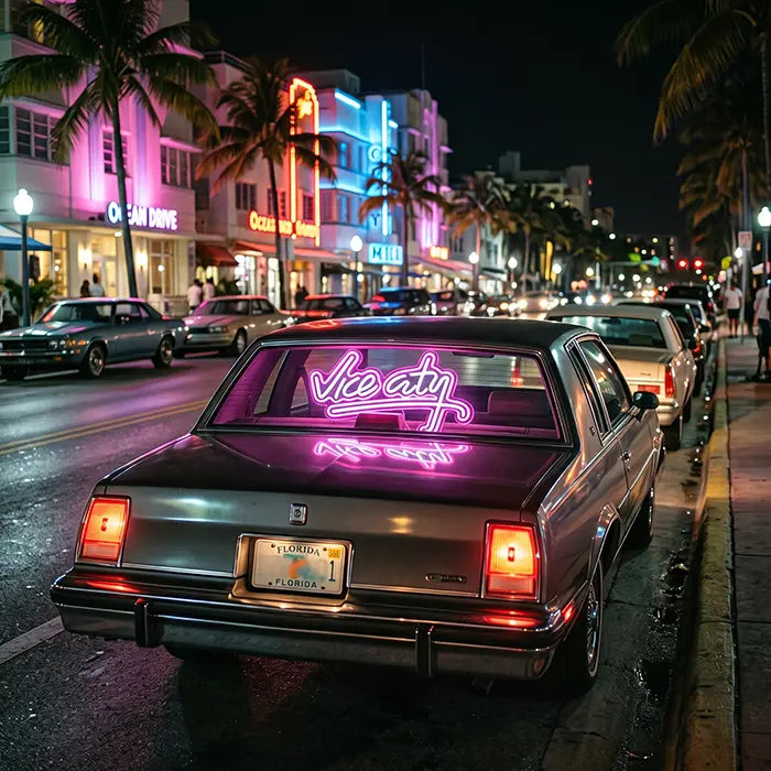 Vice City Original Neon LED Schild in der Heckscheibe eines Oldtimers auf einer Straße mit Palmen und Art-déco-Fassaden