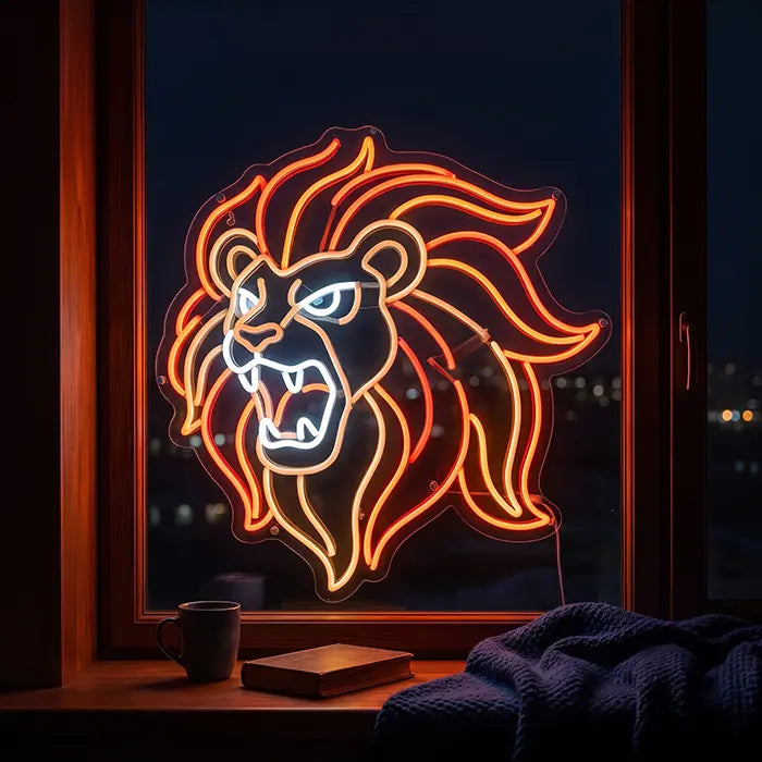 Löwenkopf Neon LED Schild im Fenster, davor eine Tasse und ein Buch auf der Fensterbank