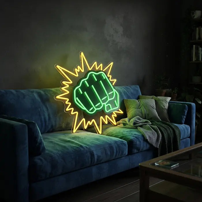 Hulk Faust Neon LED Schild lehnt an einem blauen Samtsofa und taucht die Kissen in grünes Licht