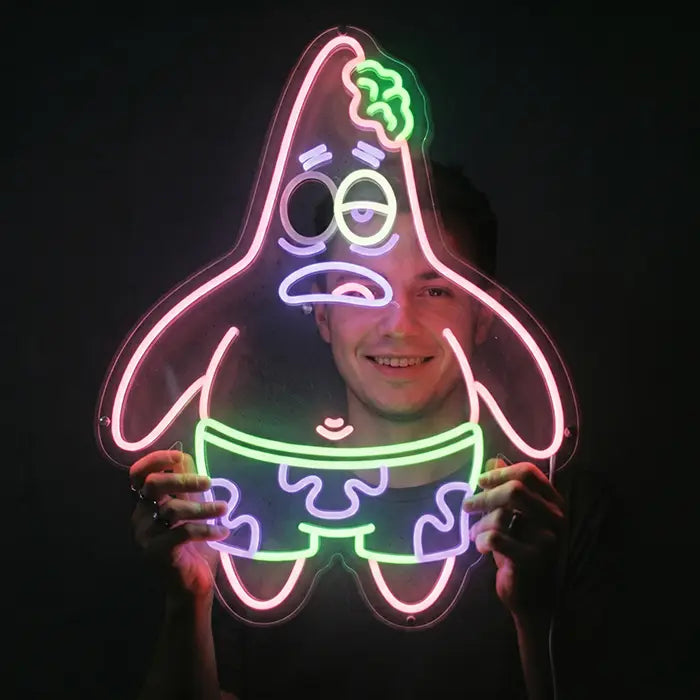 Patrick Zombie Neon LED Schild wird von einer Person vor dunklem Hintergrund in beiden Händen gehalten