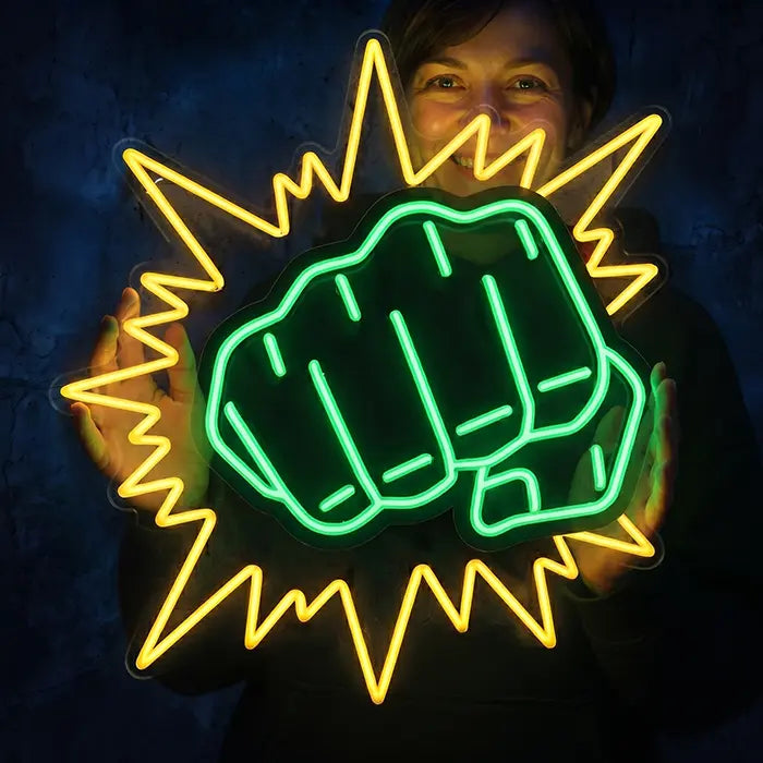 Hulk Faust Neon LED Schild wird von einer lächelnden Frau mit beiden Händen vor die Wand gehalten
