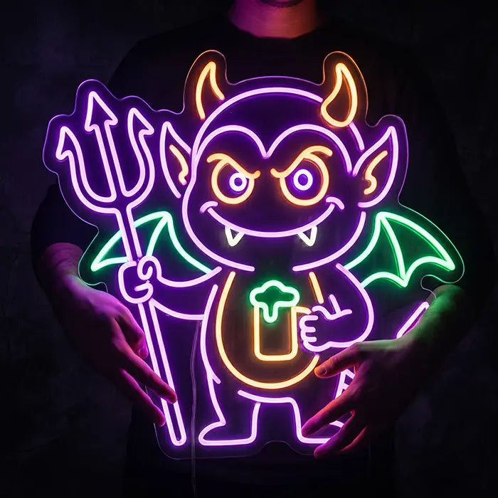 Teufel Neon LED Schild in Nahaufnahme, eine Person hält das leuchtende Schild vor dem Oberkörper