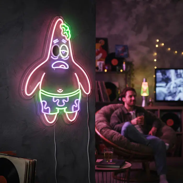 Patrick Zombie Neon LED Schild an der Wand einer Wohnzimmer-Lounge mit Schallplatten, Lavalampe und Fernseher
