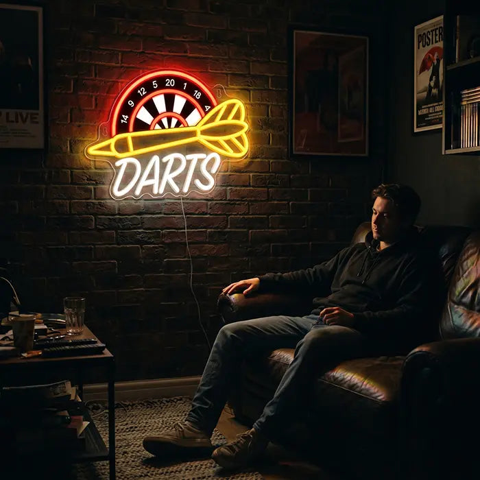 Darts Neon LED Schild mit UV-Druck an einer Backsteinwand über einem Mann im Ledersessel