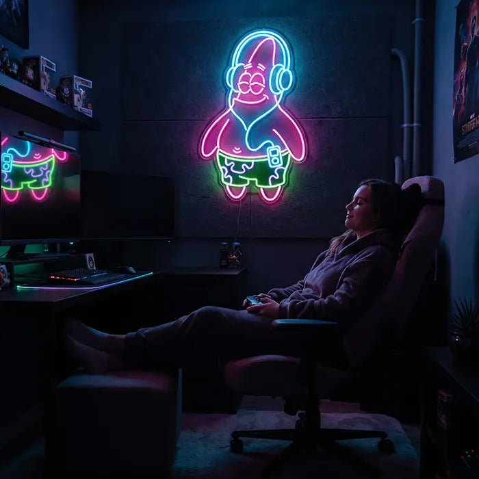 Patrick Kopfhörer Neon LED Schild über dem Schreibtisch, davor eine Gamerin mit Controller im Gaming-Stuhl