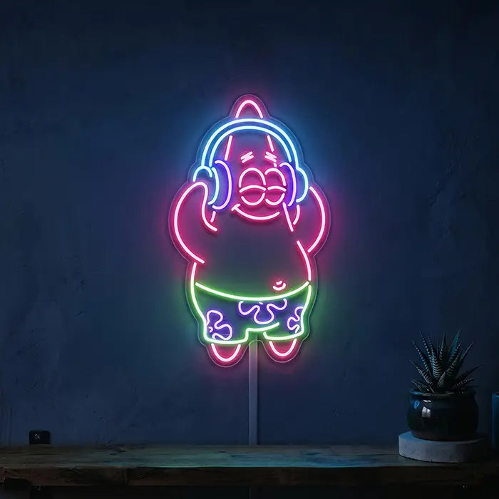 Patrick Musik Neon LED Schild an dunkelblauer Wand über einem Holzregal mit kleiner Zimmerpflanze