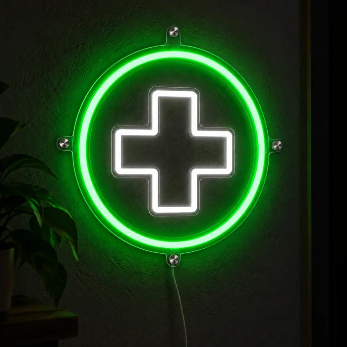 Apothekenkreuz Neon LED Schild leuchtend an einer dunklen Wand, Nahaufnahme mit Anschlusskabel