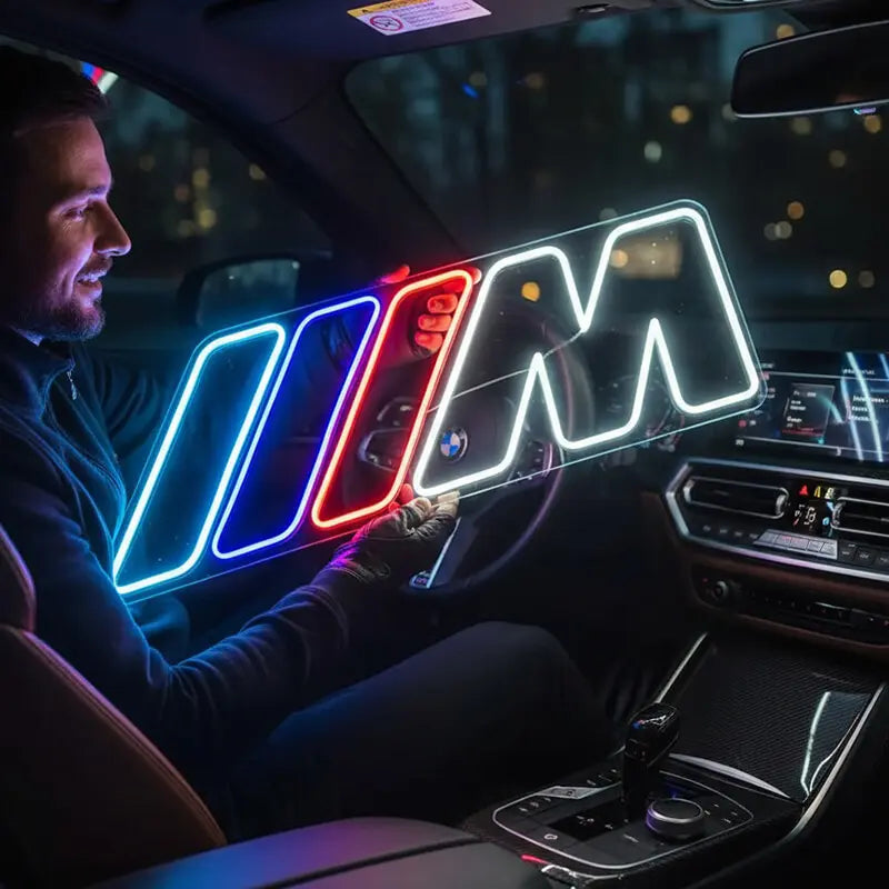 Leuchtendes Neon-Schild mit dem BMW M Logo in den charakteristischen Farben Blau, Violett und Rot sowie einem weißen "M", platziert auf einem Holzschrank