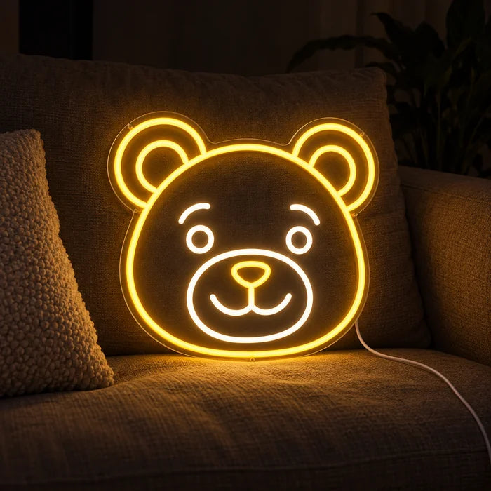 Bärenlächeln Neon LED Schild auf einem gemütlichen Sofa zwischen Kissen und Decke